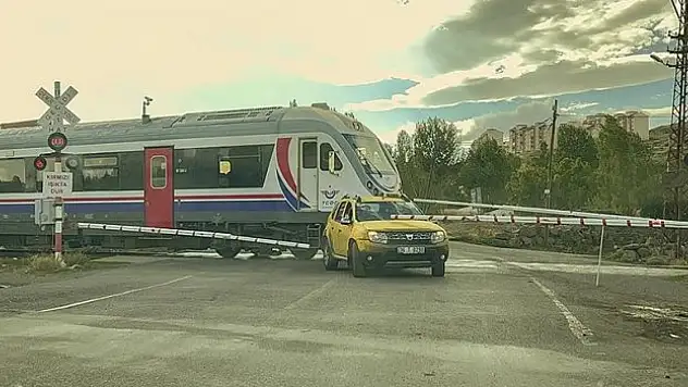 Bariyerlerin kapanmasıyla hemzemin geçitte kalan taksi, trenle çarpışmaktan 'kıl payı' kurtuldu