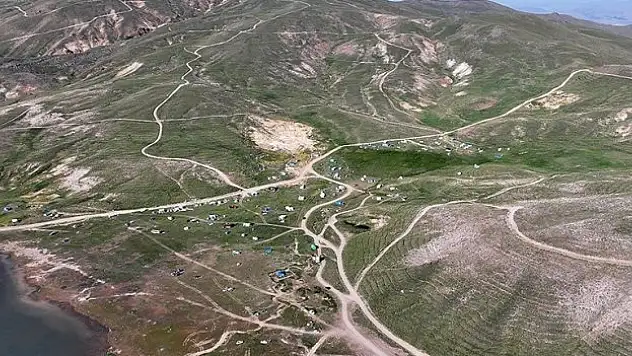 Kavurucu sıcaktan bunalıp geldikleri Erciyes'te sobayla ısınıyorlar