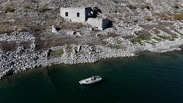 Su altında kalan mahallesinin üzerinde balık avlıyor