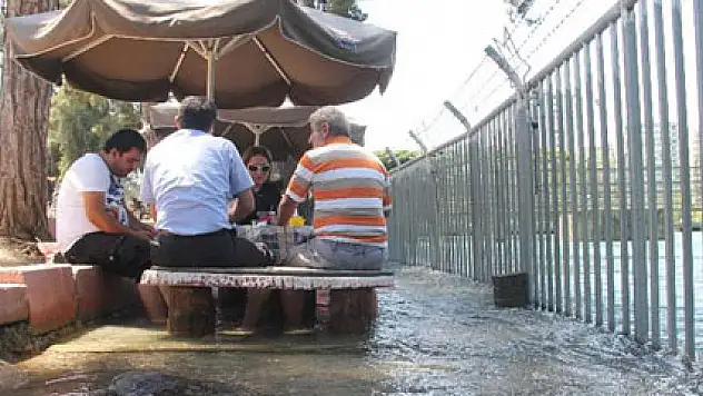 Kanaldan taşan sularla serinliyorlar