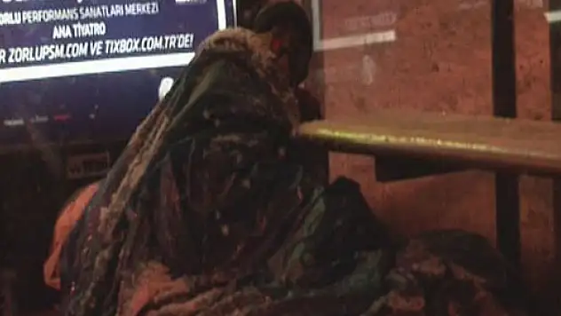 Evsiz vatandaş soğuk havada otobüs durağında yatıyor