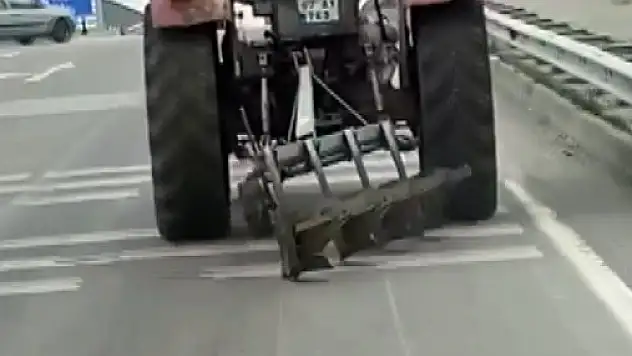 Traktör arkasındaki sabanla asfaltı çizerek karayolunda seyir etti