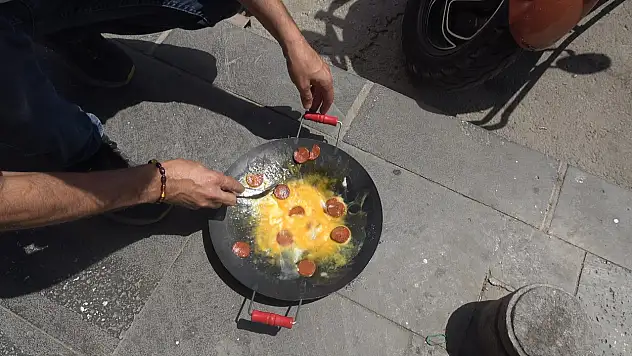 Beton zeminin üzerinde sucuklu yumurta pişirdi