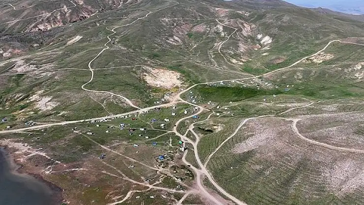 Kavurucu sıcaktan bunalıp geldikleri Erciyes'te sobayla ısınıyorlar