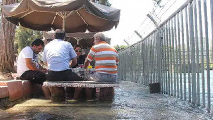 Kanaldan taşan sularla serinliyorlar