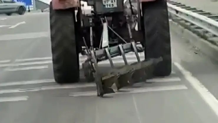 Traktör arkasındaki sabanla asfaltı çizerek karayolunda seyir etti