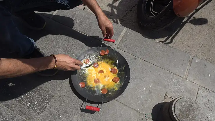 Beton zeminin üzerinde sucuklu yumurta pişirdi