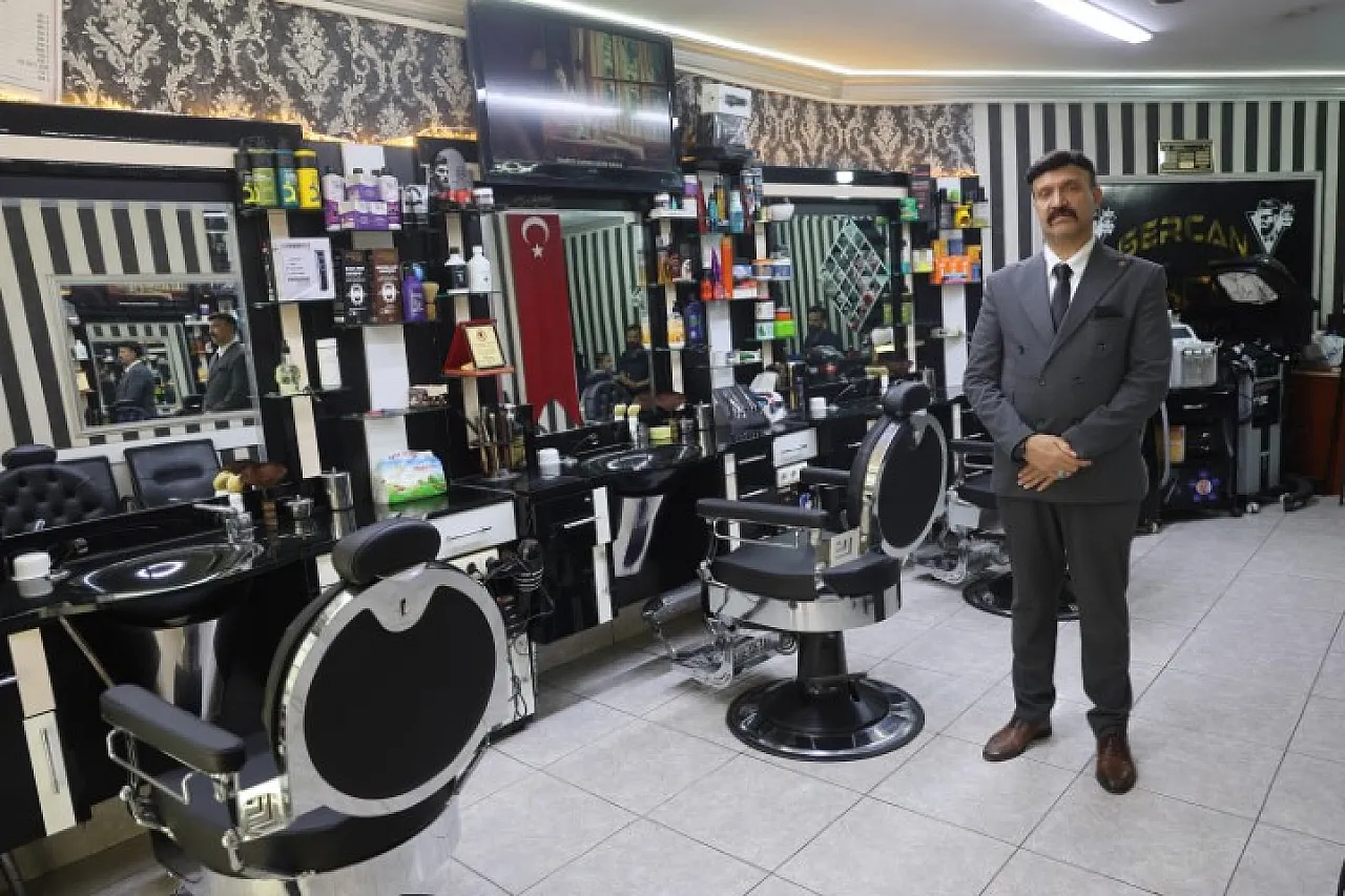 Müşterilerini takım elbiseyle traş ediyor