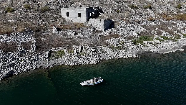 Su altında kalan mahallesinin üzerinde balık avlıyor