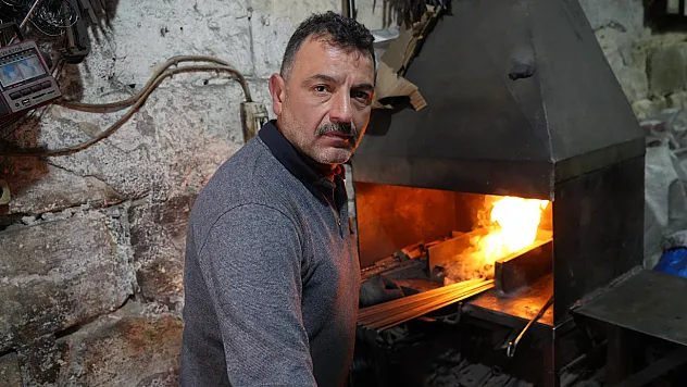 Kızgın ocağın başında hem demir dövüyor hemde vucudunu ısıtıyor