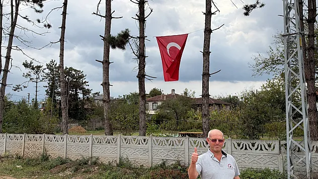 İş makinesinin üzerine çıkıp Türk bayrağını düzeltti, ardından öptü