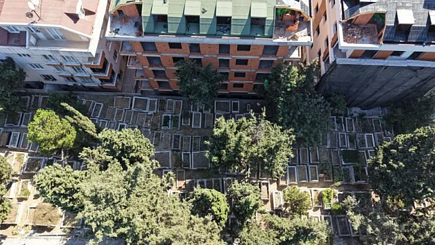 Mezarlığın dibine yeni binalar yapıldı: Dairelerden mezar taşları görünüyor